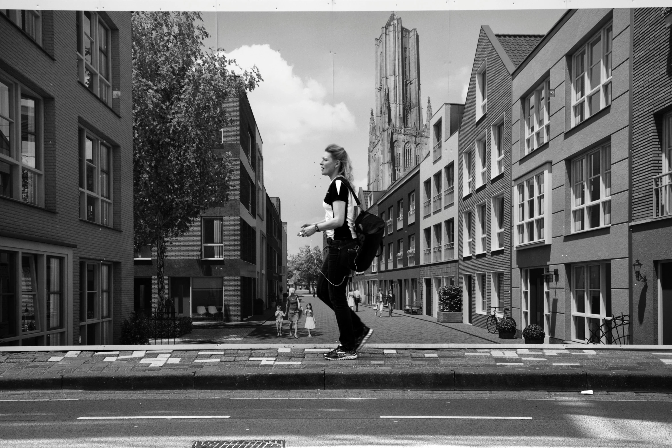 a man with a cell phone walking across a street