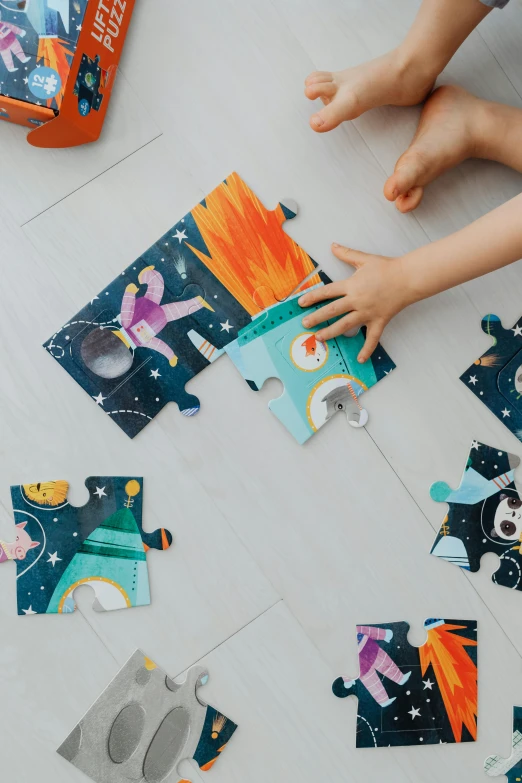 a young child holding a piece of puzzle on the floor