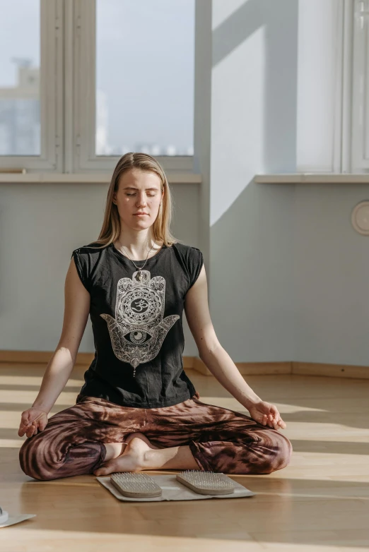 woman sitting in yoga pose in an empty room