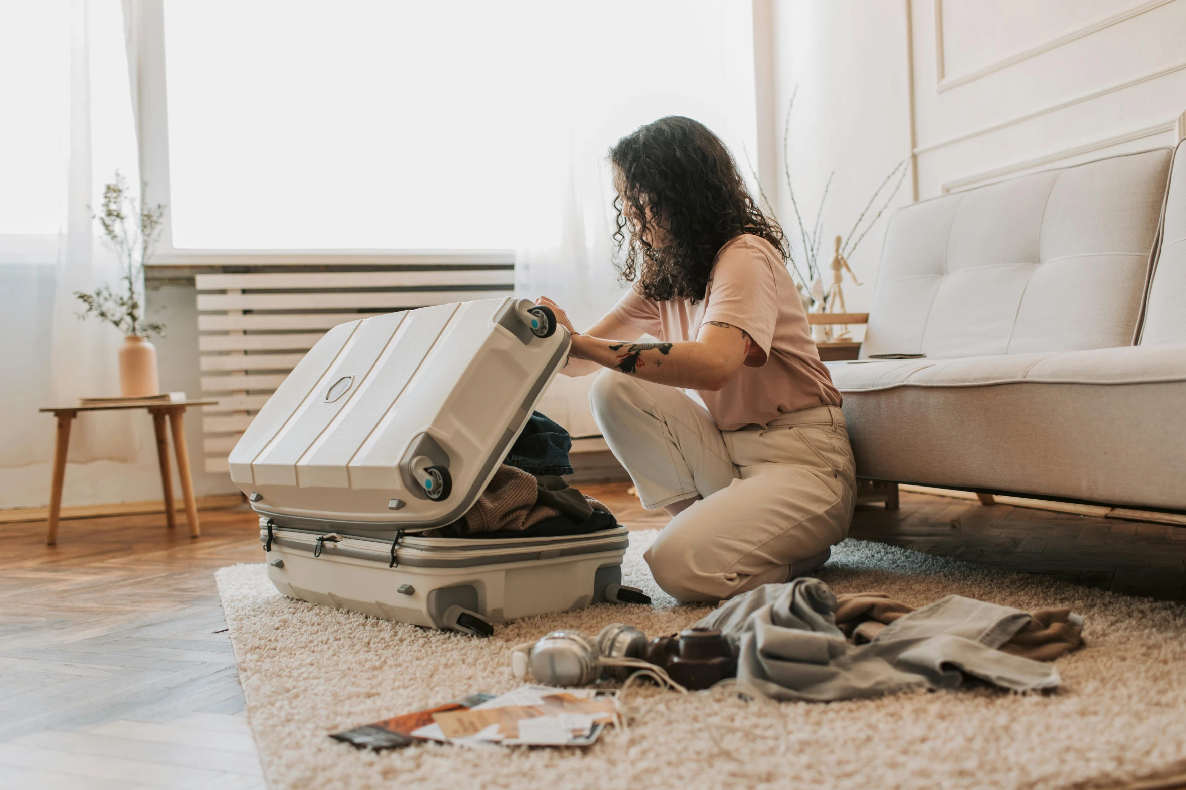 a woman packing her suitcase on the floor