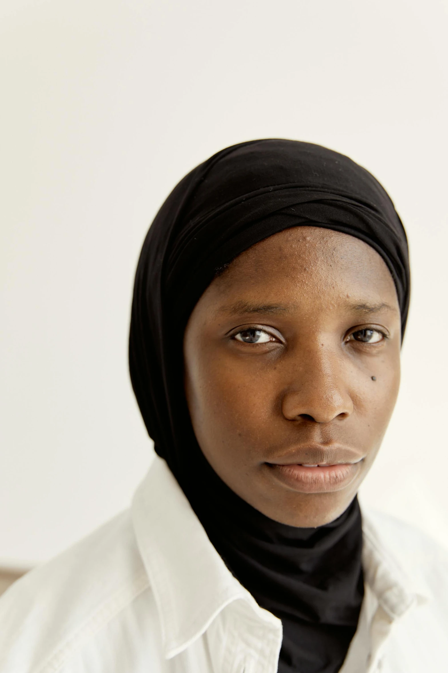 a woman wearing a head scarf poses for a po