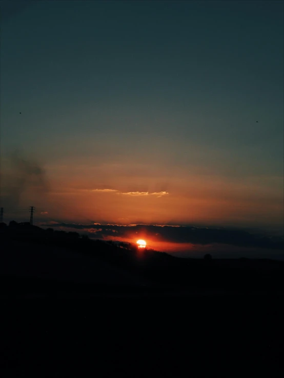 the setting sun in the sky as seen from the mountains