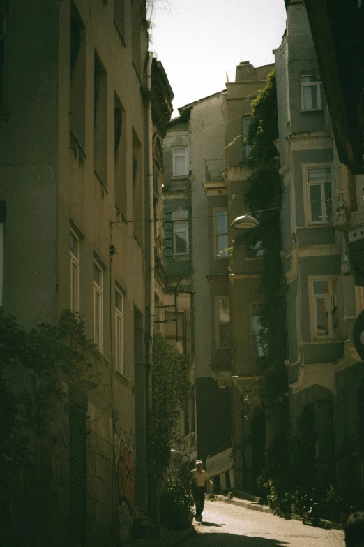 an alley way between two buildings with a person walking down one