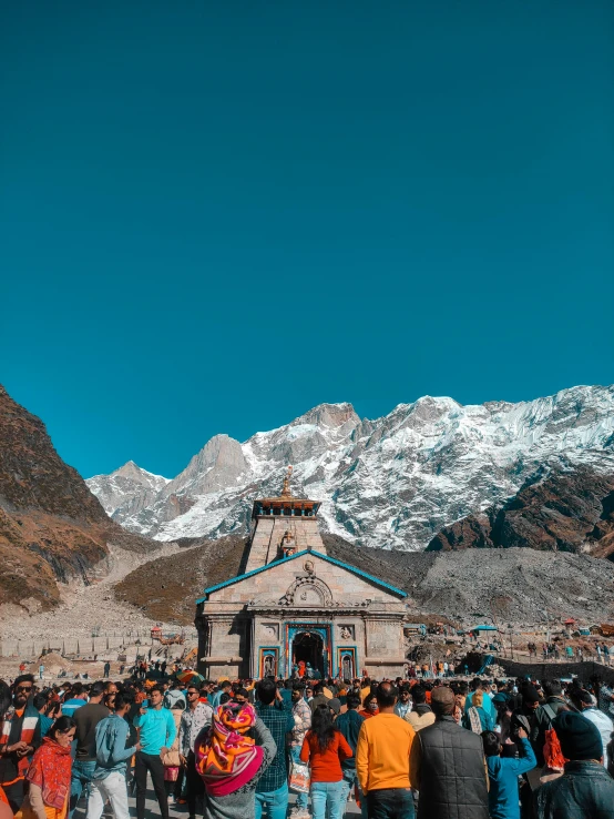 a large crowd of people walking next to some mountains