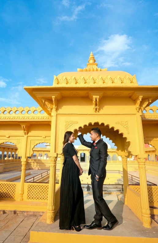 a couple is standing in front of a small gazebo