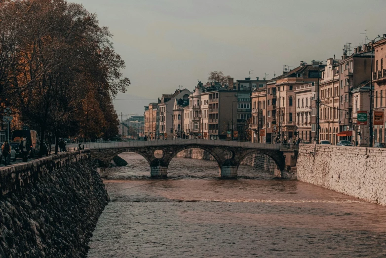 an old bridge is spanning the river