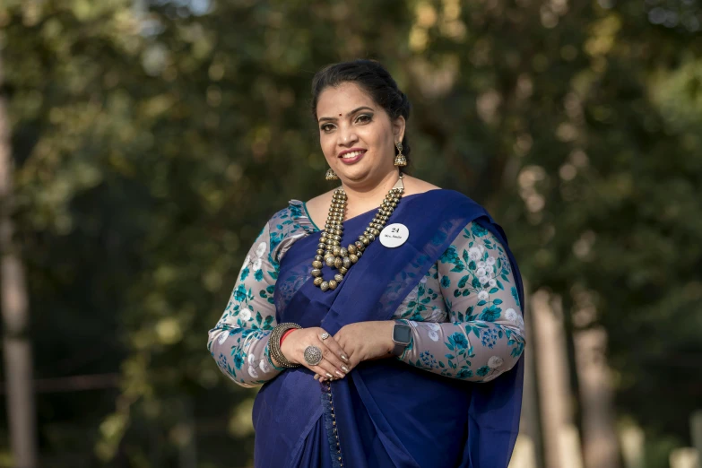 a woman wearing a blue sari and a necklace