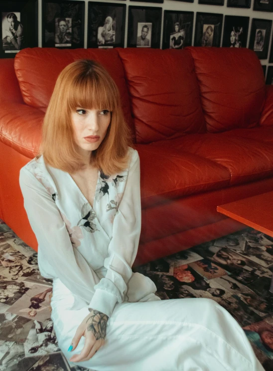 a woman sitting on top of a red couch