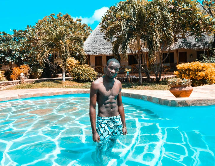 man in blue trunks standing in swimming pool looking forward