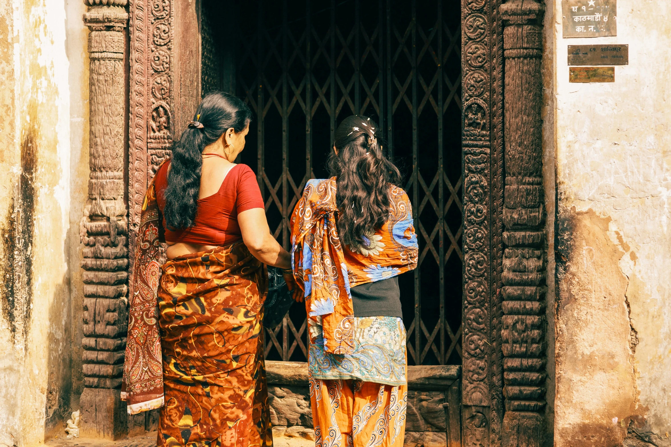 two women are standing at a doorway near each other