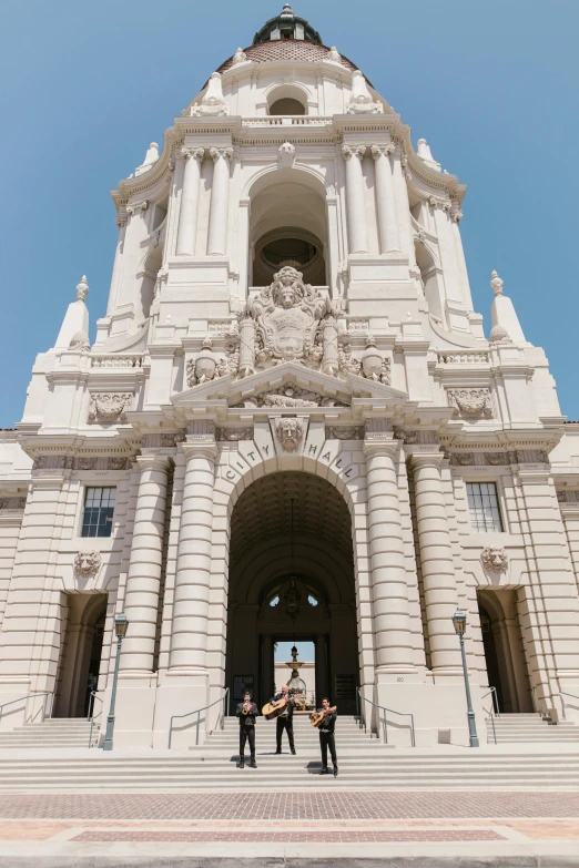 two men standing in front of a large white building