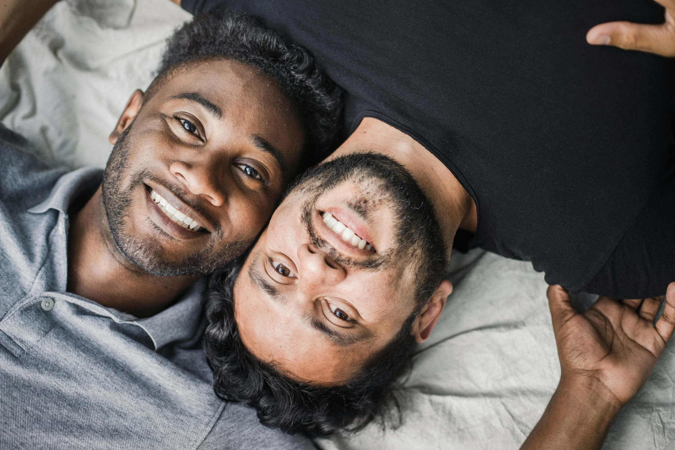 a man and a woman are posing together on the bed