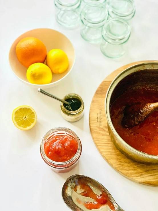 a metal container filled with tomato sauce, and several other jars with lemons and mint