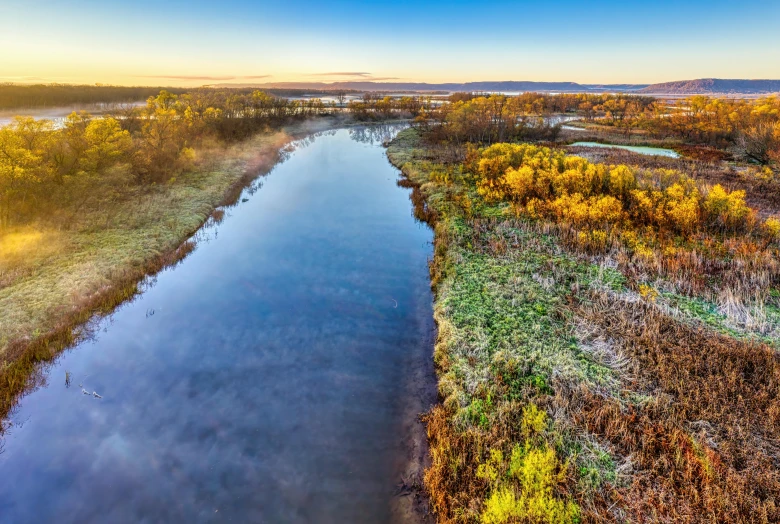 an aerial view of a canal in a green field