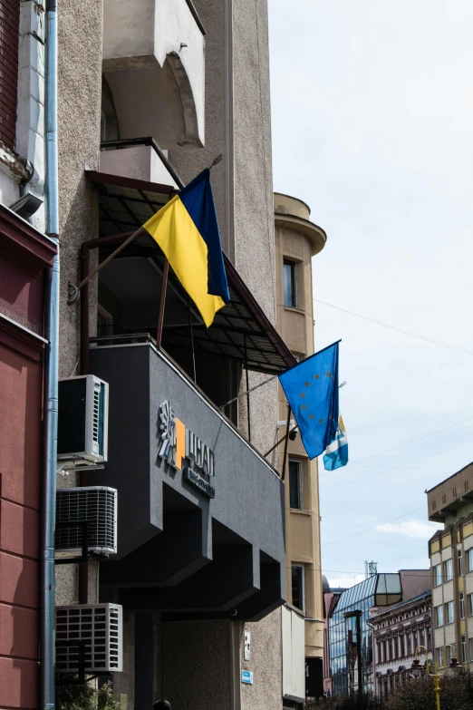 a few flags hanging from the side of a building