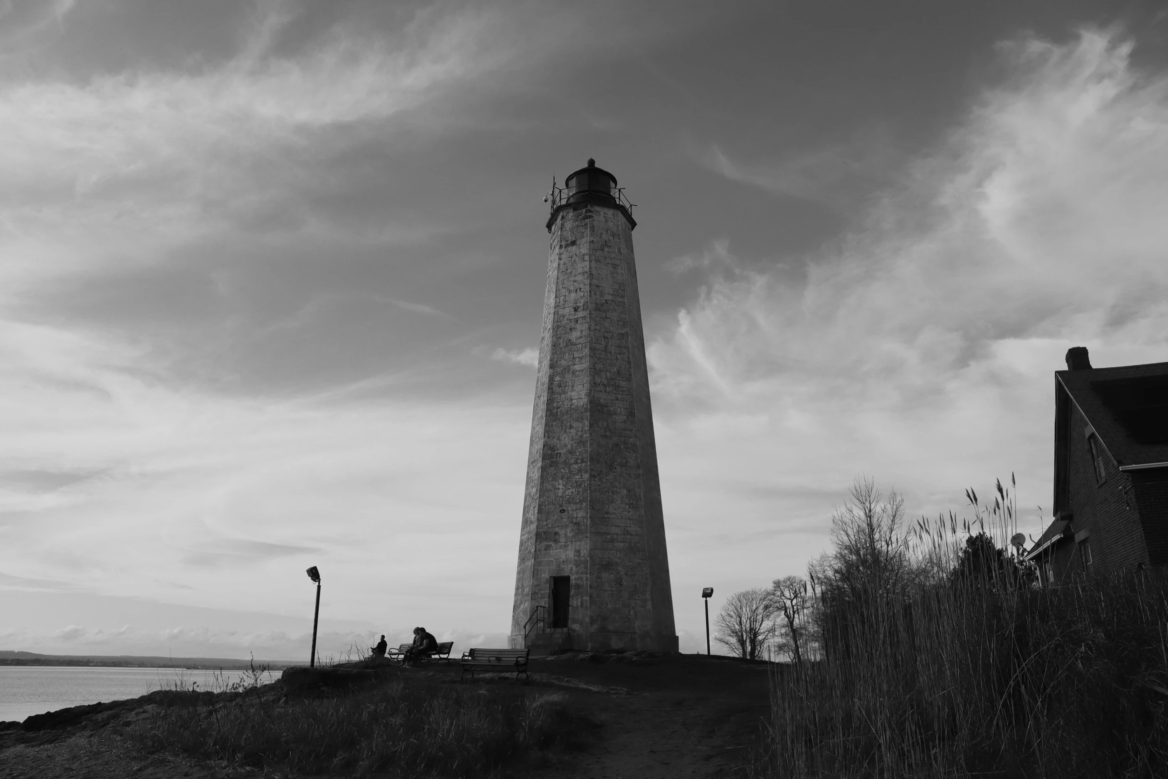 a light tower is seen against a cloudy sky