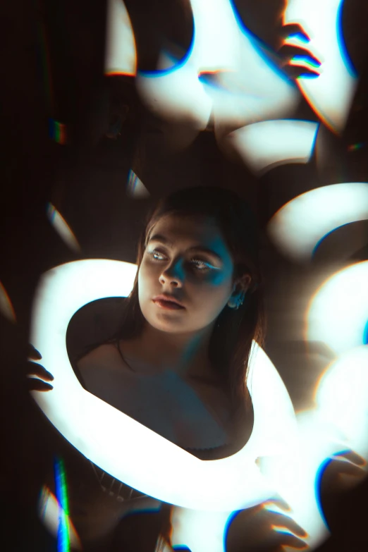 a woman looks at herself through some blue light