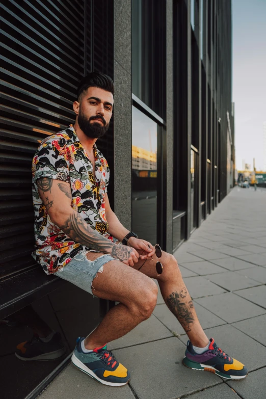 a man with a tattoo sitting on a building ledge