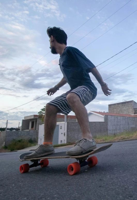 a boy with sunglasses skateboarding down the road