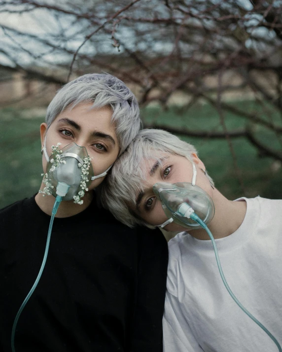 two people with respirator masks posing for a po