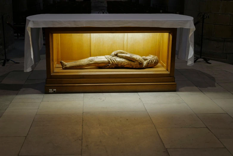 a display case containing wooden body and a cloth dd over it