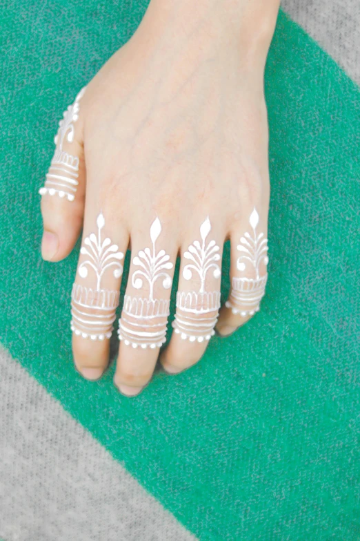 a white hand with a lace and bead design