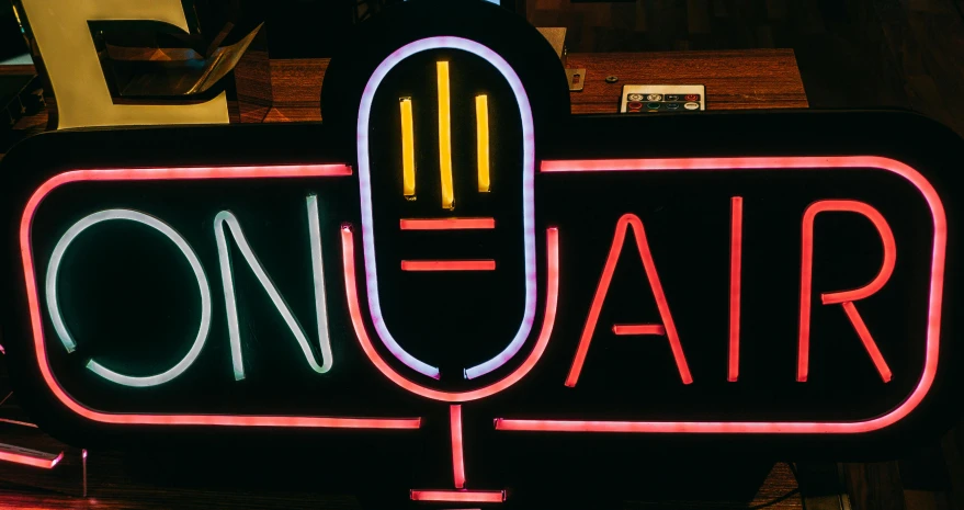 this neon sign has an image of a microphone on it