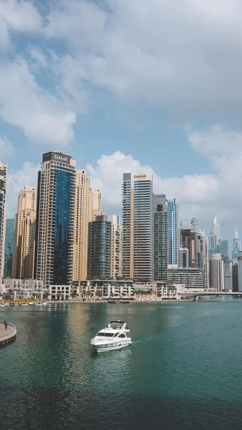 some tall buildings on the water and some boats