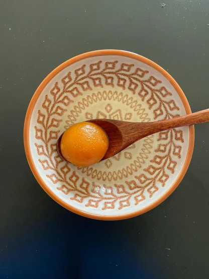 an orange is in a bowl on a table