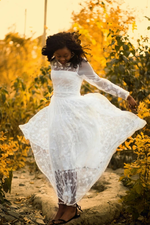 a woman is walking through a field in a white dress