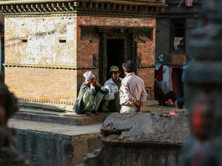 people sitting on steps in front of an old building