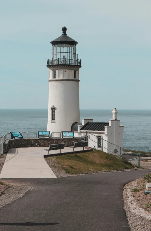 an old lighthouse by the water looks out into the distance