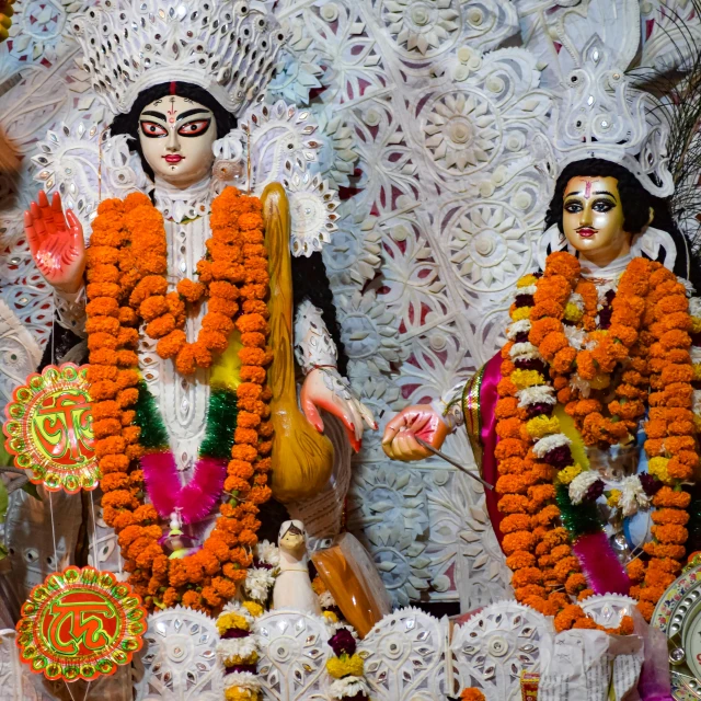 a couple of statues covered in flowers next to each other