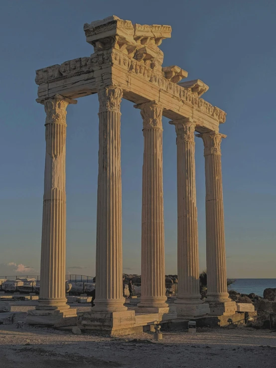 four large pillars with statues on them in the desert