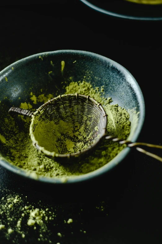 powdered green tea in a wooden spoon on a table
