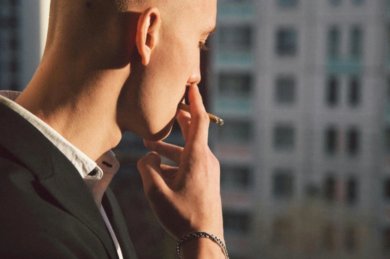 a man talking on a cell phone while smoking a cigarette