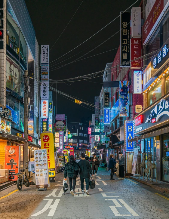 people walking around a busy street during the night