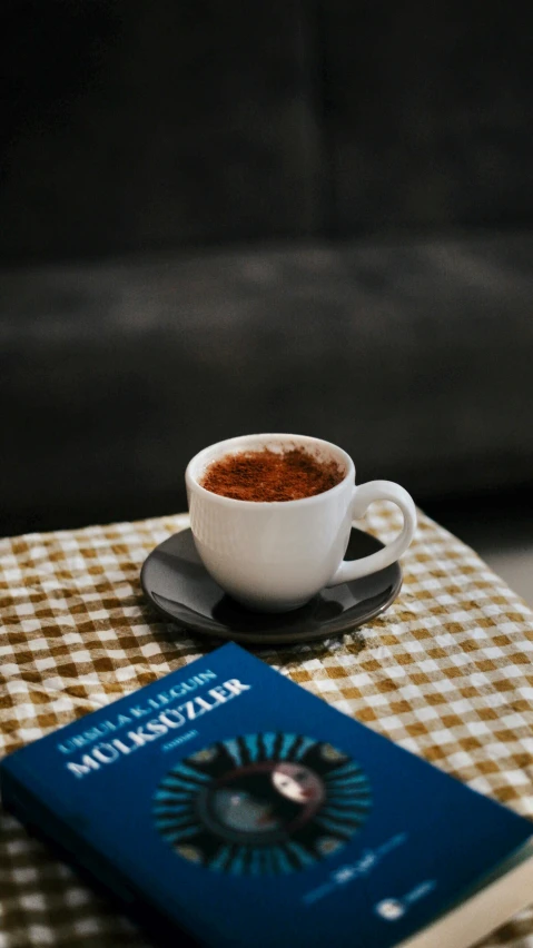 a table topped with a book and cup of coffee