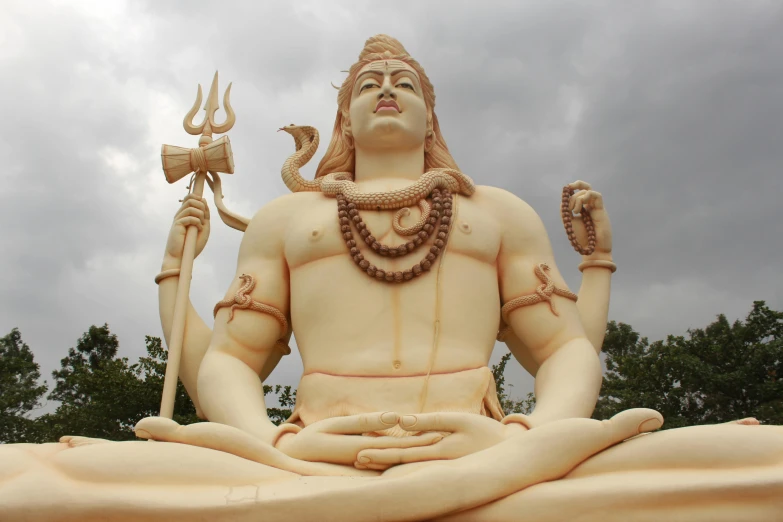 a very big statue of god sitting in a meditation position