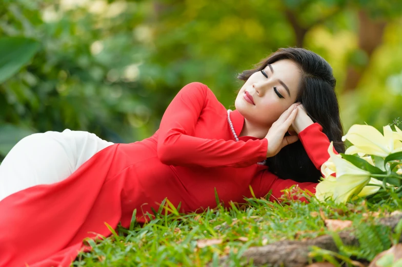 a woman in a red dress lays on the ground