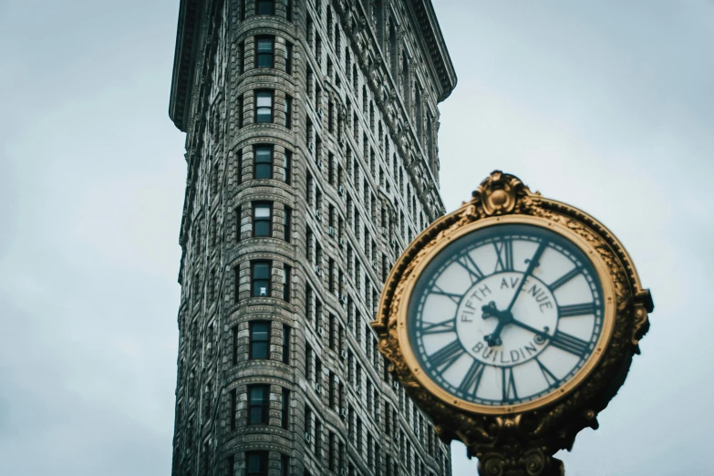 an old fashioned clock sitting in front of a building