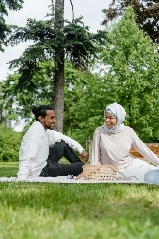 a couple sitting on a blanket in the park