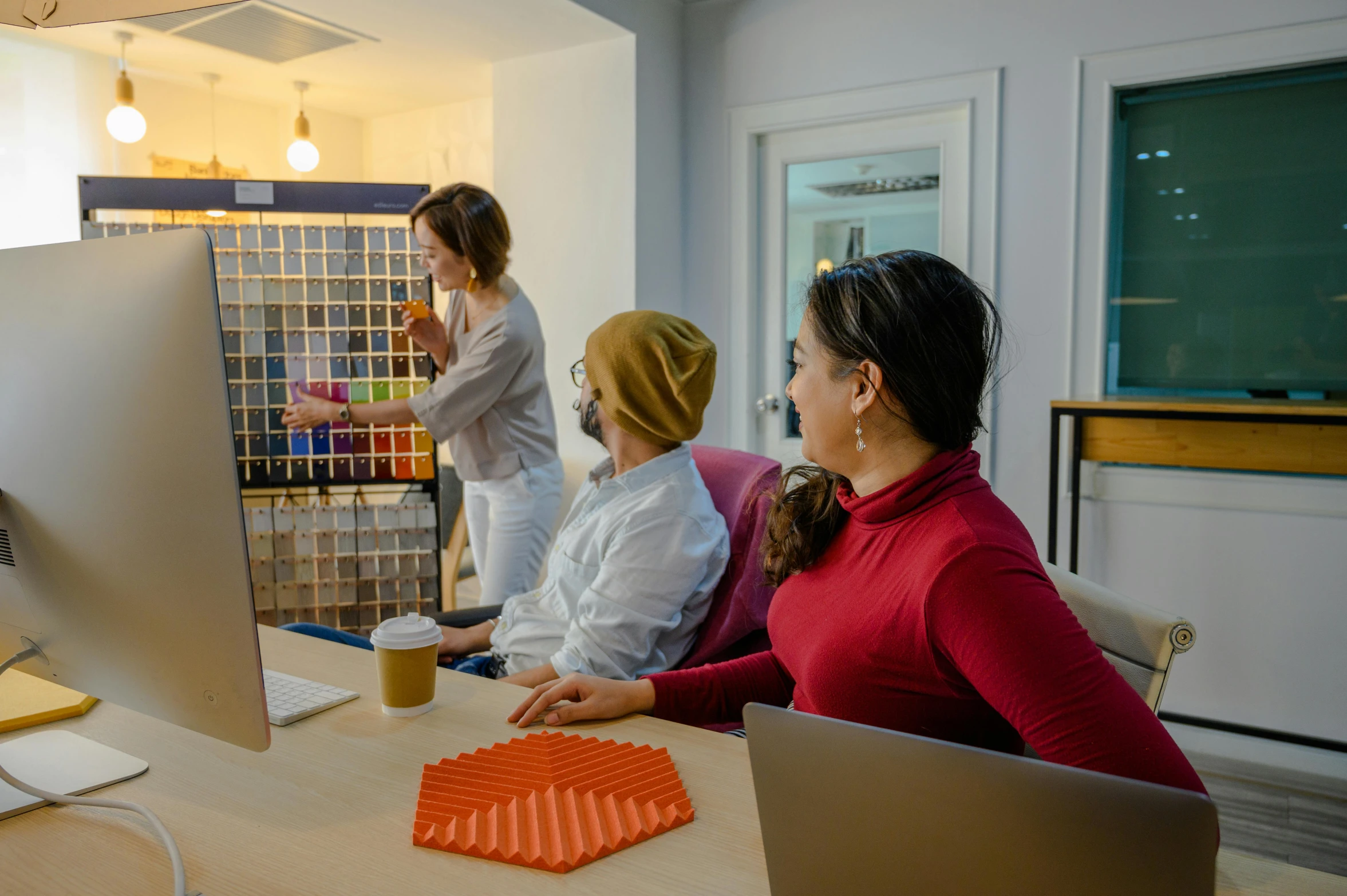 two people sitting in front of an open computer monitor