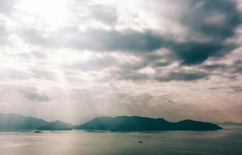 the sunbeams shine down on some small islands in the ocean