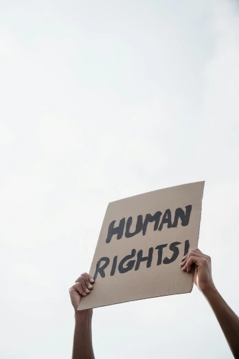 a man holds up a sign saying human rights