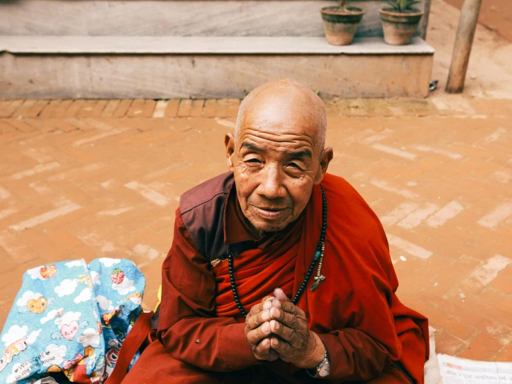 man in red robe sitting on the ground