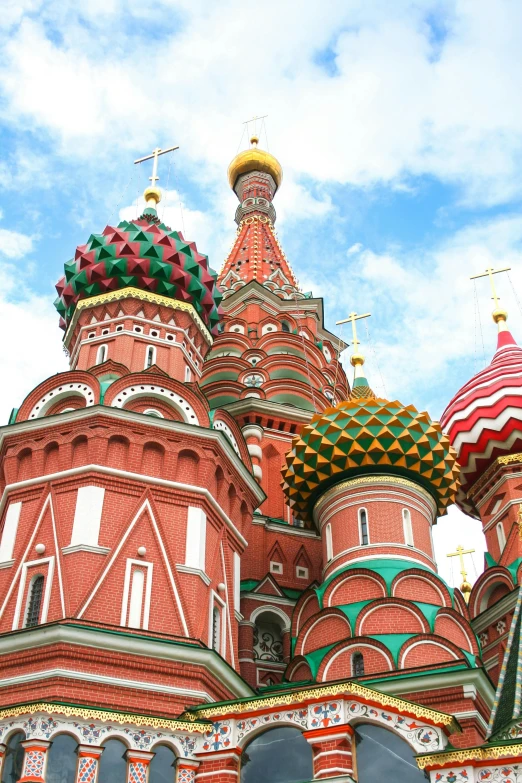 the dome and top of a large red building with several colorful spires