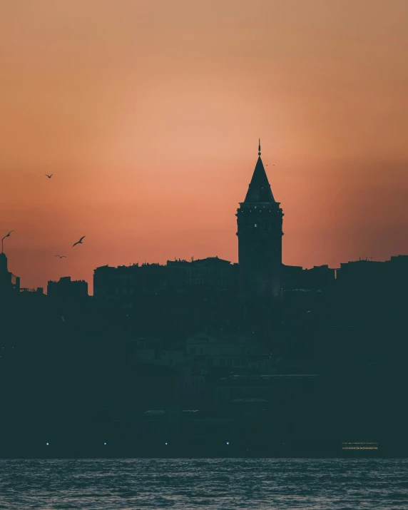 a beautiful sunrise in the background over the water and skyline