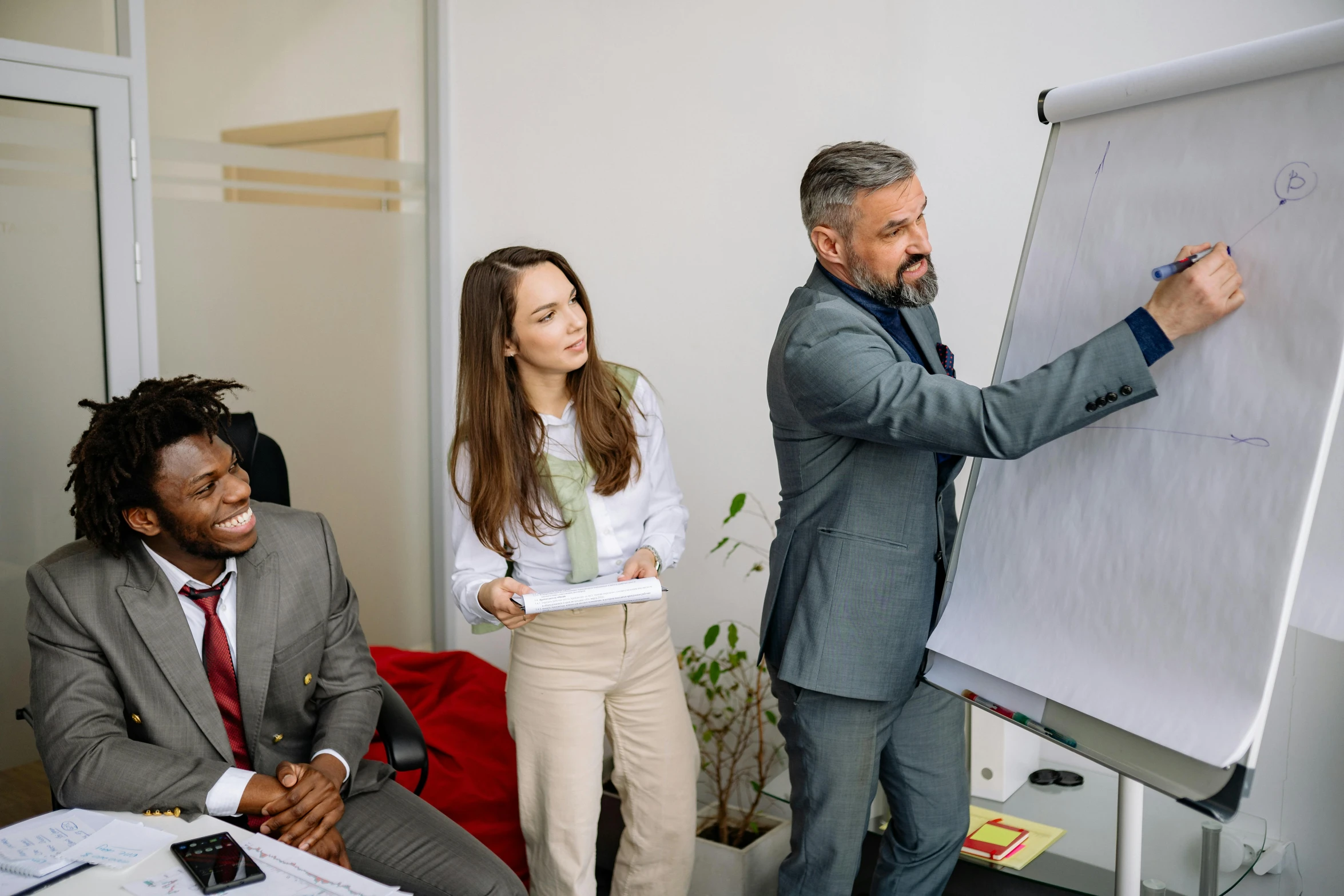 a business man standing next to a chalk board