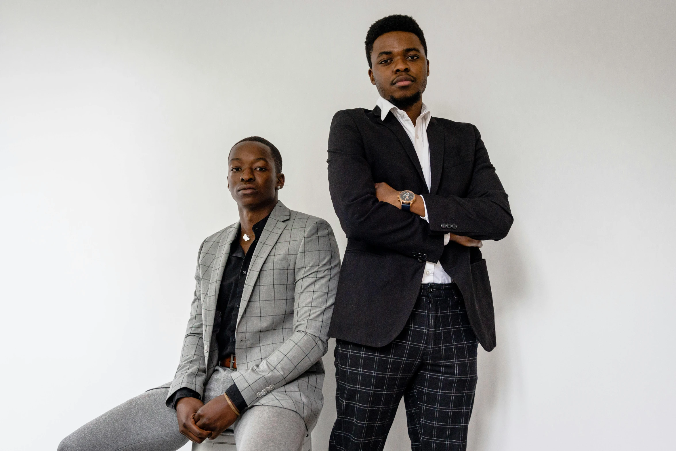 two men in ties sitting on a chair next to each other